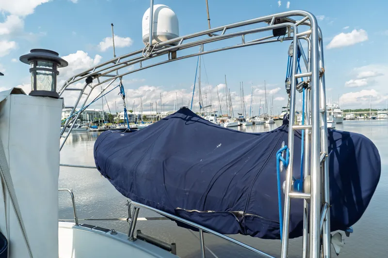 Slide: The Image of 1982 Albin 43 yacht with covered equipment, docked in a marina under a clear sky. - 15