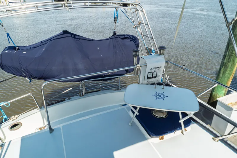 Slide: The Image of 1982 Albin 43 yacht deck with covered equipment and nautical-themed table. - 19