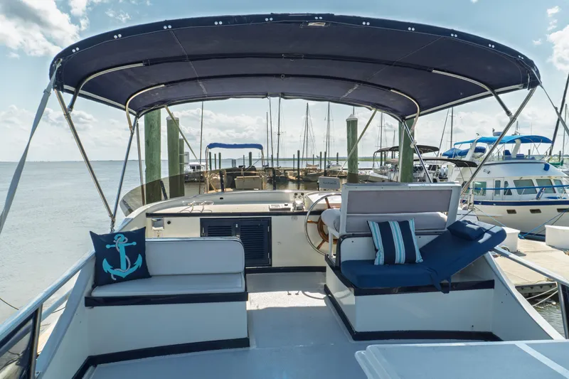 Slide: The Image of 1982 Albin 43 yacht with canopy, docked at marina, featuring nautical-themed cushions. - 22