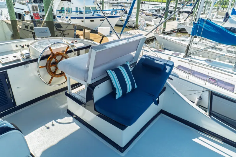 Slide: The Image of 1982 Albin 43 yacht helm with wooden wheel and blue seating in marina. - 24