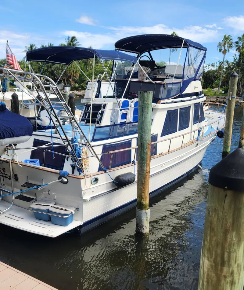 Slide: The Image of 1982 Albin 43 yacht docked at marina with blue canopy and American flag. - 3