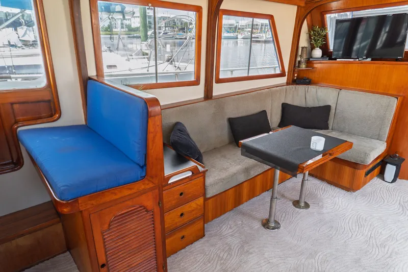 Slide: The Image of Interior of 1982 Albin 43 yacht with cozy seating and table, dock view outside. - 36
