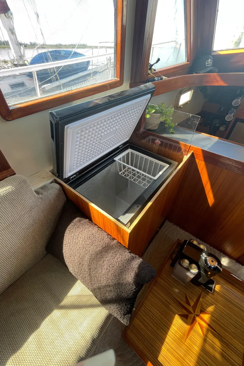 Slide: The Image of Interior of 1982 Albin 43 boat with open freezer and cozy seating area. - 38