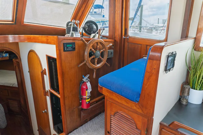 Slide: The Image of Interior of 1982 Albin 43 boat with wooden helm, blue seat, and nautical decor. - 40