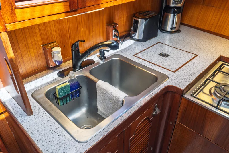 Slide: The Image of 1982 Albin 43 yacht kitchen with stainless steel sink, countertop, and appliances. - 57