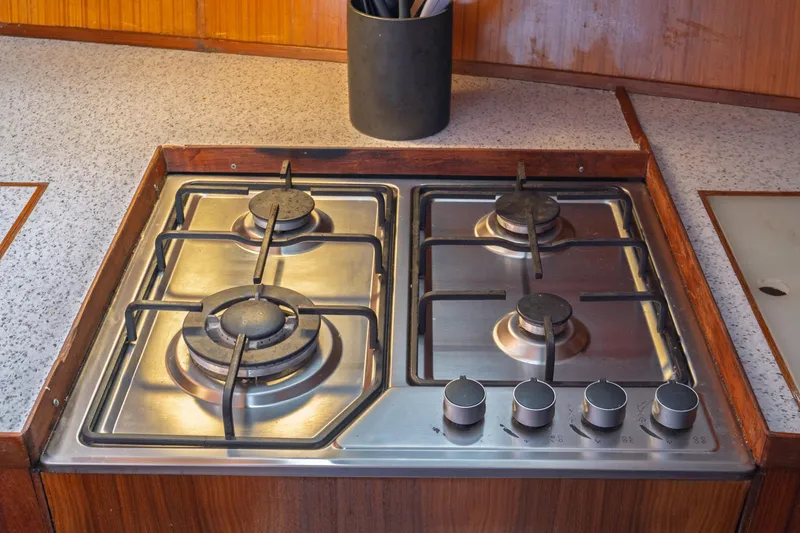 Slide: The Image of Four-burner gas stove on 1982 Albin 43 yacht, set in wooden countertop. - 58