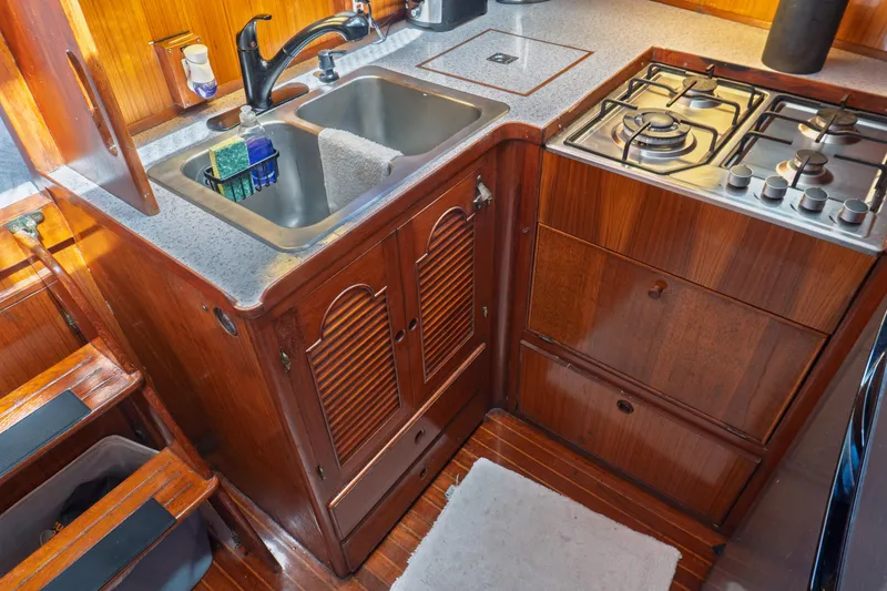 Slide: The Image of 1982 Albin 43 yacht kitchen with wooden cabinetry, sink, and gas stove. - 59