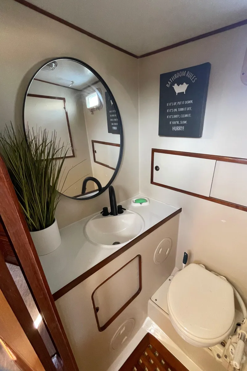 Slide: The Image of 1982 Albin 43 yacht bathroom with round mirror, sink, and toilet. - 66