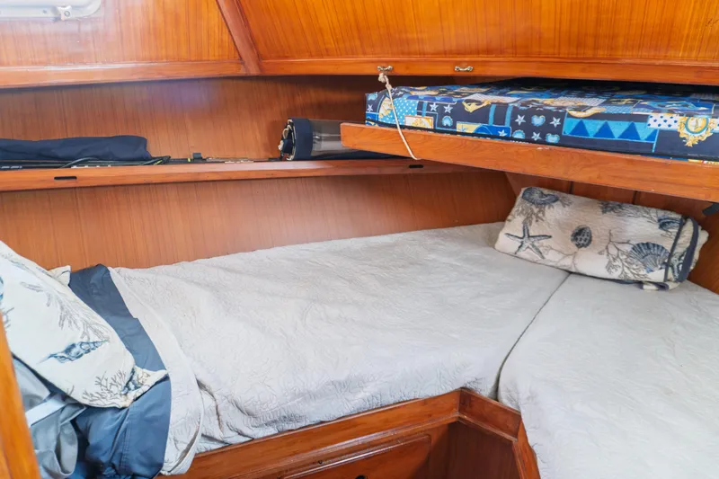 Slide: The Image of 1982 Albin 43 yacht cabin with wooden interior and cozy bedding. - 68