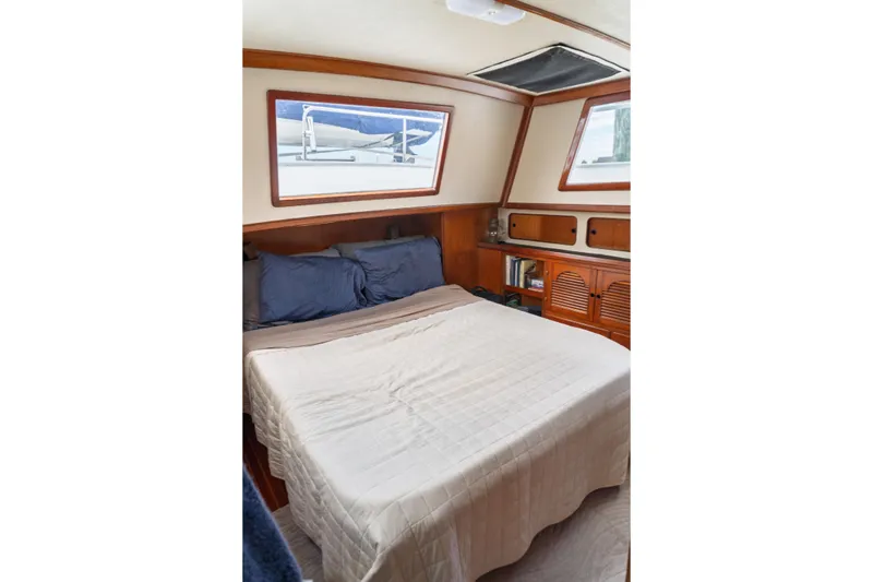 Slide: The Image of Cozy bedroom interior of 1982 Albin 43 yacht with wooden cabinetry and large windows. - 74