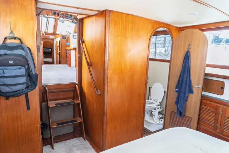 Slide: The Image of 1982 Albin 43 yacht interior with wooden paneling, ladder, and bathroom. - 78