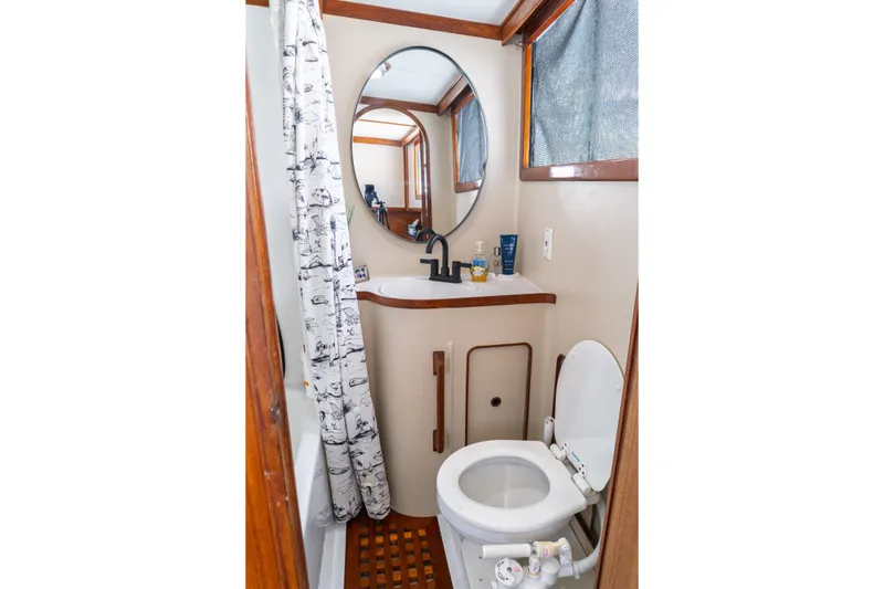 Slide: The Image of Compact bathroom in 1982 Albin 43 boat with shower, toilet, and round mirror. - 80