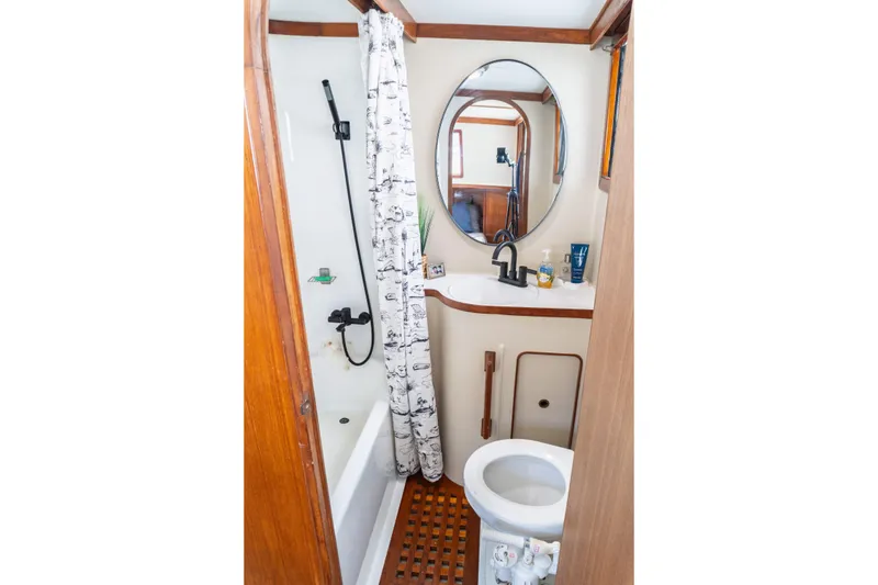 Slide: The Image of 1982 Albin 43 yacht bathroom with shower, sink, and toilet, featuring wood accents. - 81