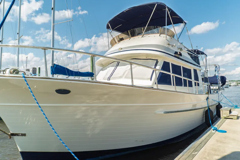 Slide: The Image of 1982 Albin 43 yacht docked, featuring classic design and blue canopy under a clear sky. - 9