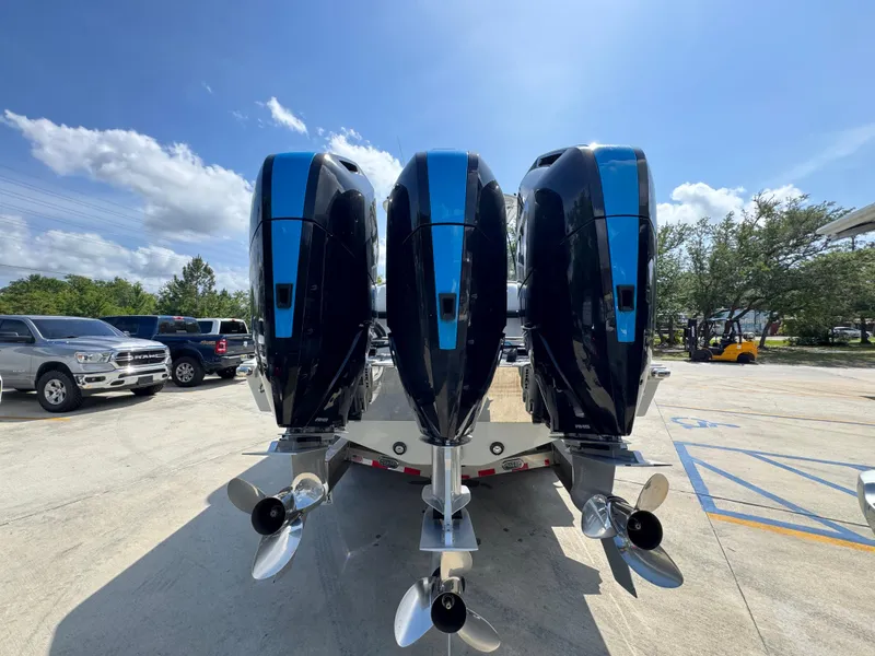 Slide: The Image of 2023 Front Runner 36 Center Console with triple outboard engines, parked outdoors. - 14