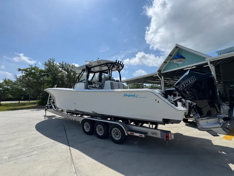 Slide: The Image of 2023 Front Runner 36 Center Console boat on trailer, featuring powerful outboard engines. - 17