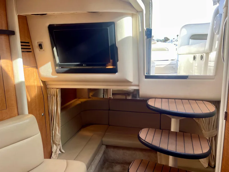 Slide: The Image of Interior of 2006 Sea Ray 320 Sundancer with TV, seating, and wooden steps. - 11