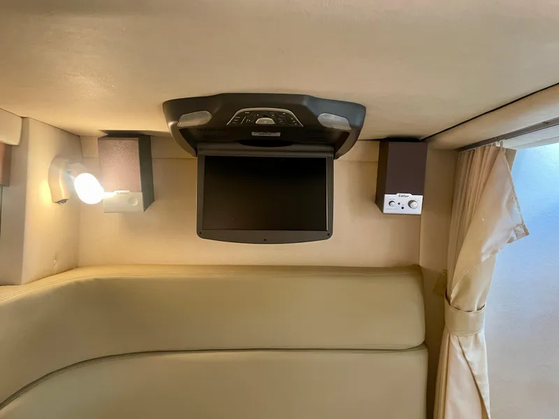 Slide: The Image of Interior of 2006 Sea Ray 320 Sundancer with TV, speakers, and cozy seating. - 13