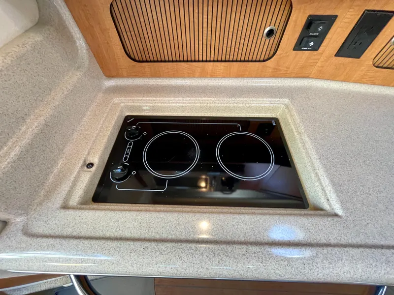 Slide: The Image of Stovetop in 2006 Sea Ray 320 Sundancer yacht kitchen, featuring sleek design and modern controls. - 16