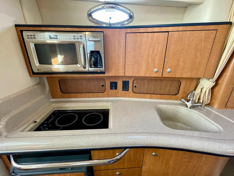 Slide: The Image of 2006 Sea Ray 320 Sundancer kitchen with microwave, stove, and sink. - 17