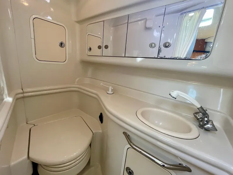 Slide: The Image of 2006 Sea Ray 320 Sundancer bathroom with sink, toilet, and storage cabinets. - 21