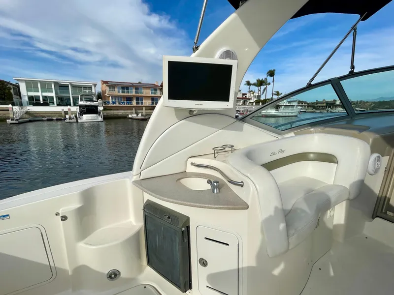 Slide: The Image of 2006 Sea Ray 320 Sundancer boat interior with seating, sink, and mounted TV. - 27