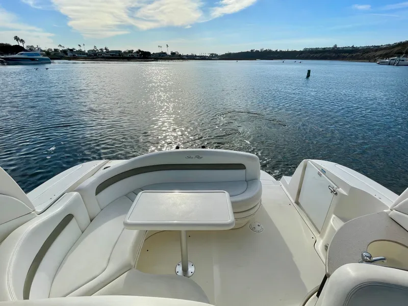 Slide: The Image of 2006 Sea Ray 320 Sundancer boat interior with seating and table on calm water. - 29