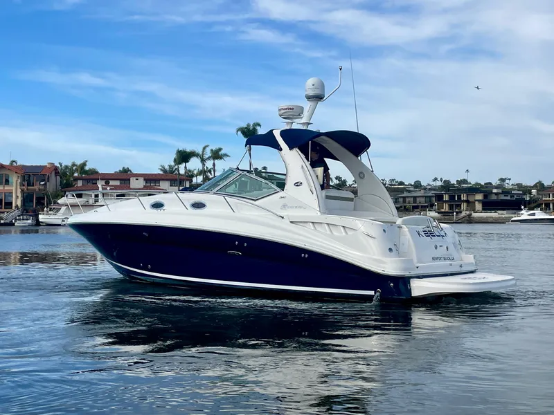Slide: The Image of 2006 Sea Ray 320 Sundancer yacht on calm water, blue sky background. - 5