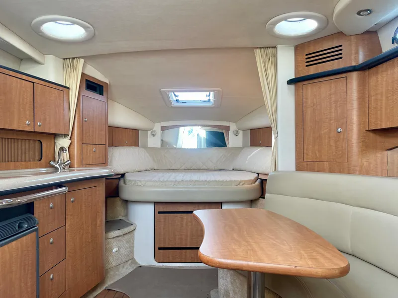 Slide: The Image of Interior of 2006 Sea Ray 320 Sundancer with wood cabinetry and cozy seating area. - 7