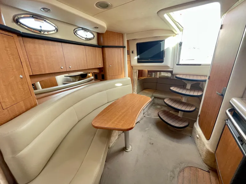 Slide: The Image of Interior of 2006 Sea Ray 320 Sundancer yacht with seating, table, and stairs. - 9