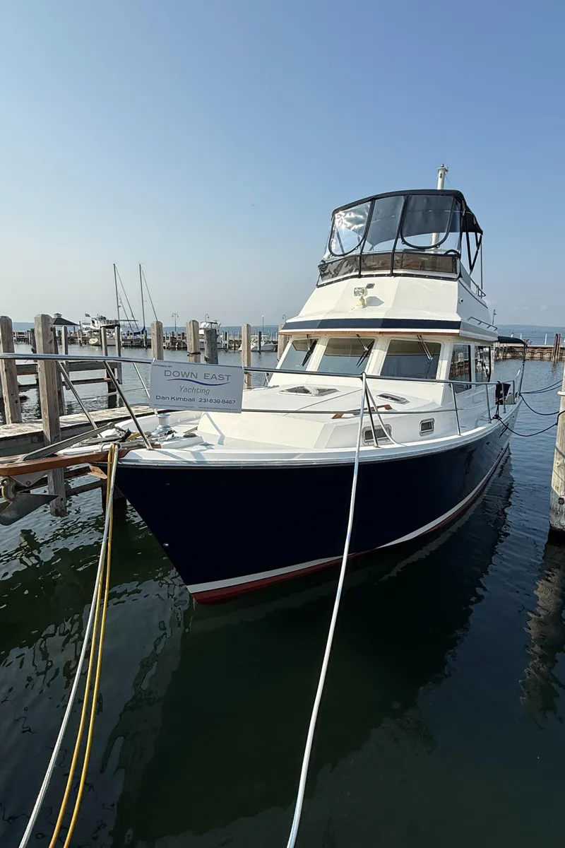 Slide: The Image of 1999 Sabreline 34 Flybridge boat docked at marina, clear sky, calm water. - 10