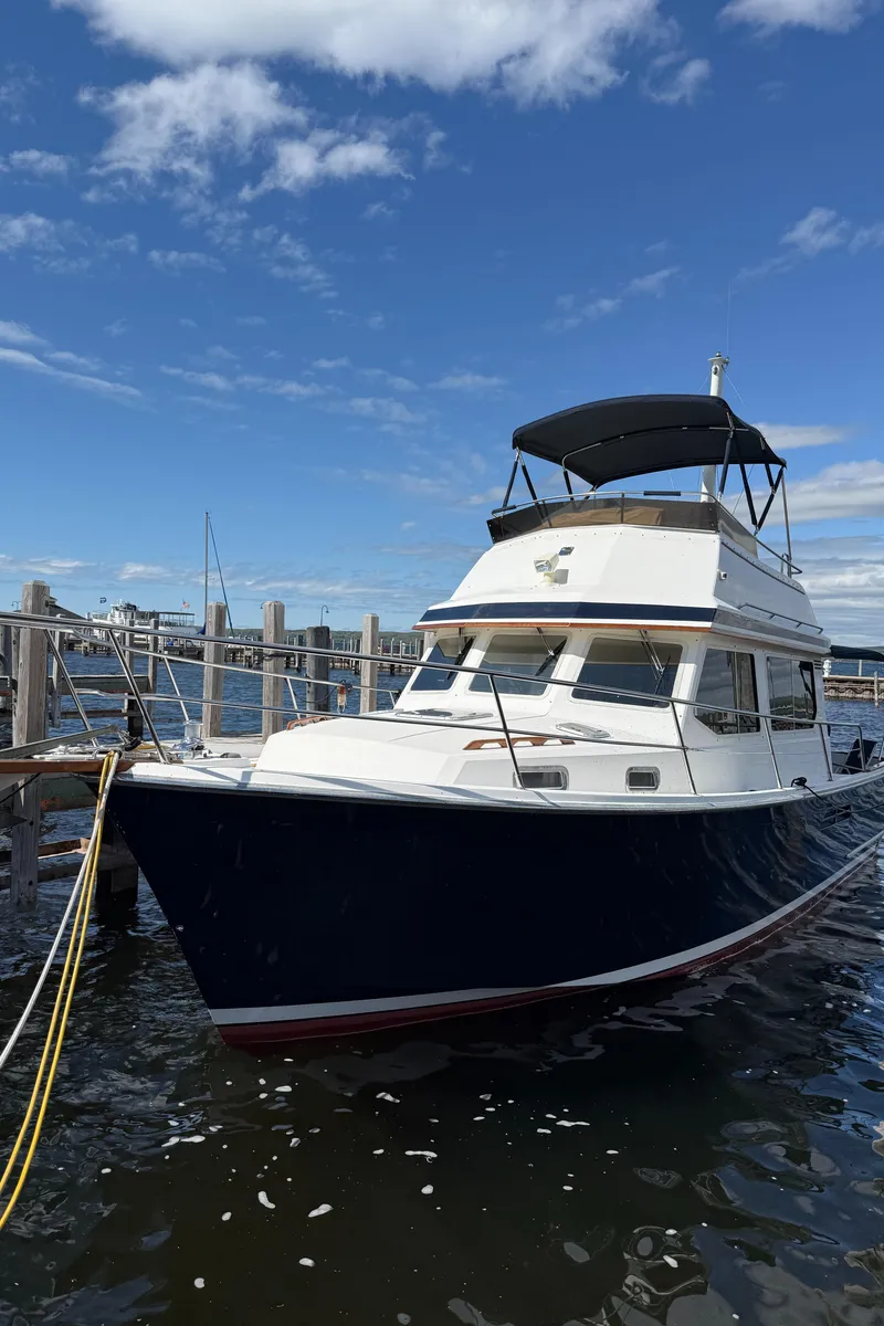 Slide: The Image of 1999 Sabreline 34 Flybridge boat docked under a clear blue sky. - 14