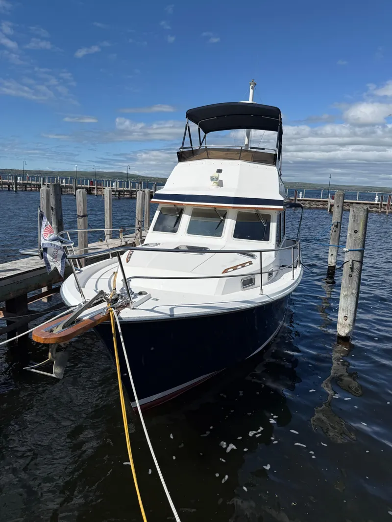 Slide: The Image of 1999 Sabreline 34 Flybridge boat docked at marina under clear blue sky. - 15