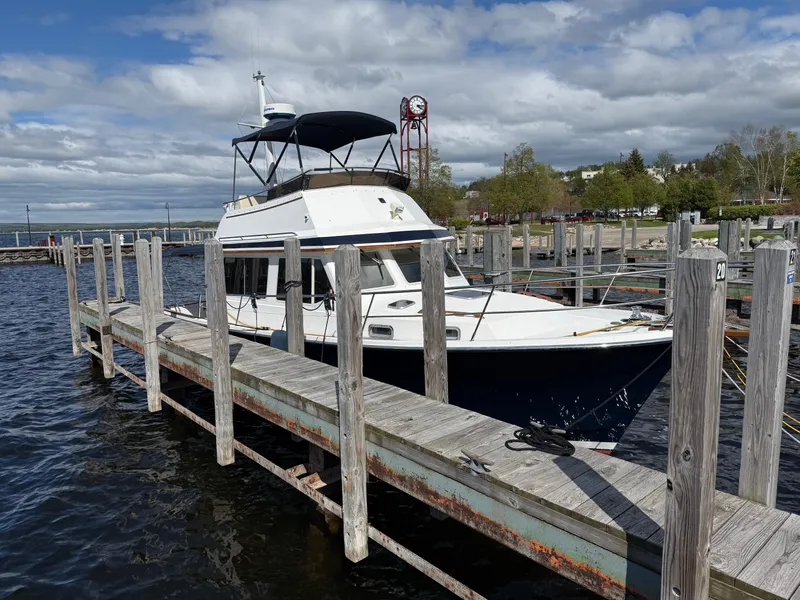 Slide: The Image of Sabreline 34 Flybridge 1999 docked at a marina under a cloudy sky. - 16
