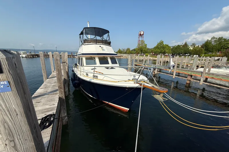 Slide: The Image of 1999 Sabreline 34 Flybridge yacht docked at a marina on a sunny day. - 17