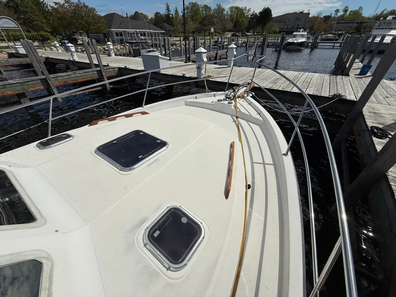 Slide: The Image of 1999 Sabreline 34 Flybridge boat docked at a marina, showcasing deck and hatch details. - 28
