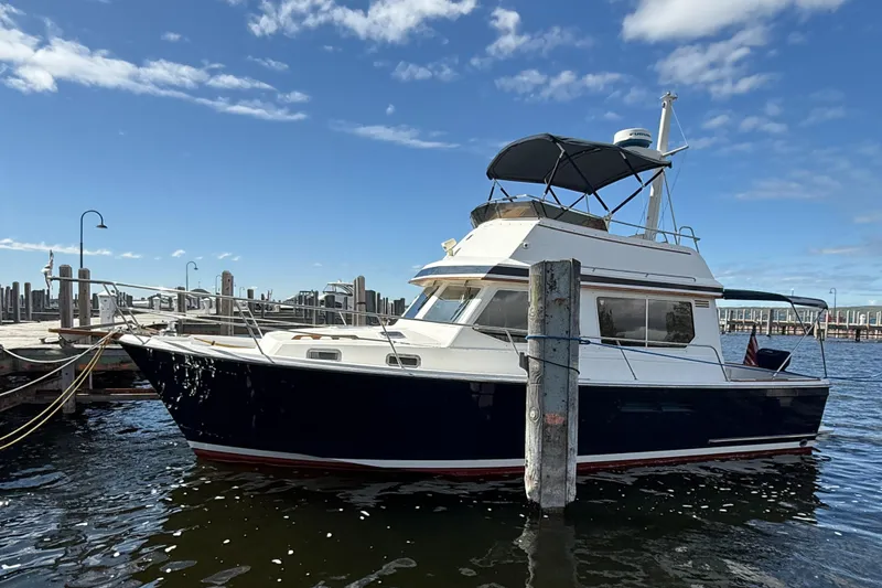 Slide: The Image of 1999 Sabreline 34 Flybridge boat docked at marina under blue sky. - 3