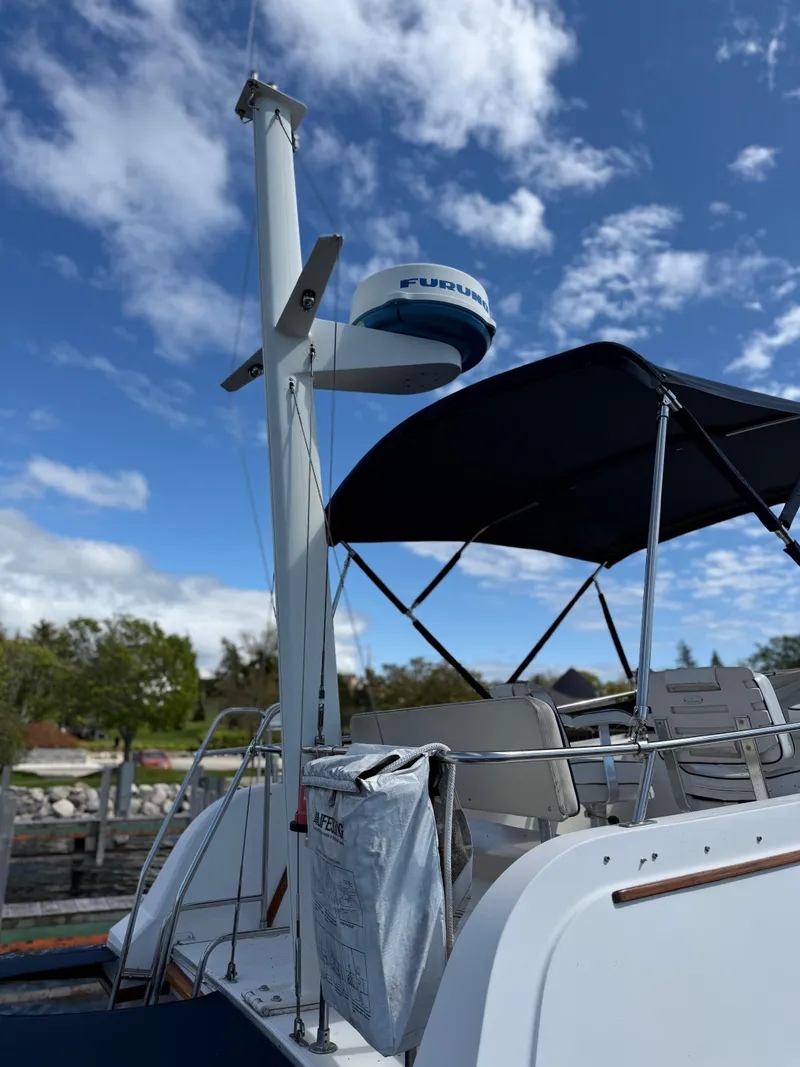 Slide: The Image of 1999 Sabreline 34 Flybridge boat with radar, blue canopy, and clear sky background. - 36