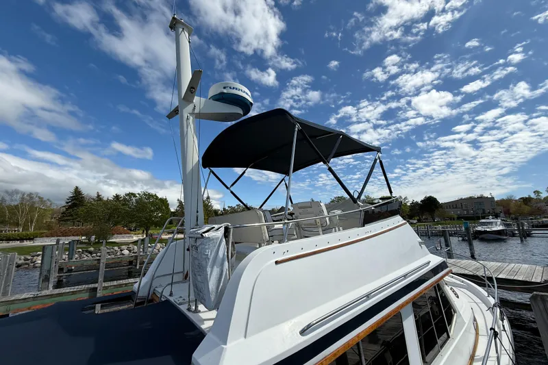 Slide: The Image of 1999 Sabreline 34 Flybridge boat docked under a partly cloudy sky. - 37