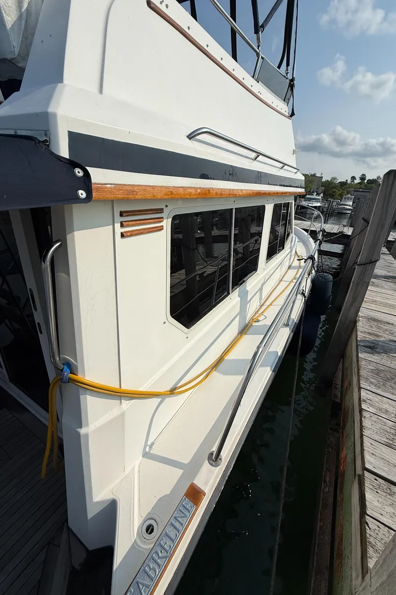 Slide: The Image of 1999 Sabreline 34 Flybridge yacht docked, showcasing sleek design and exterior details. - 38