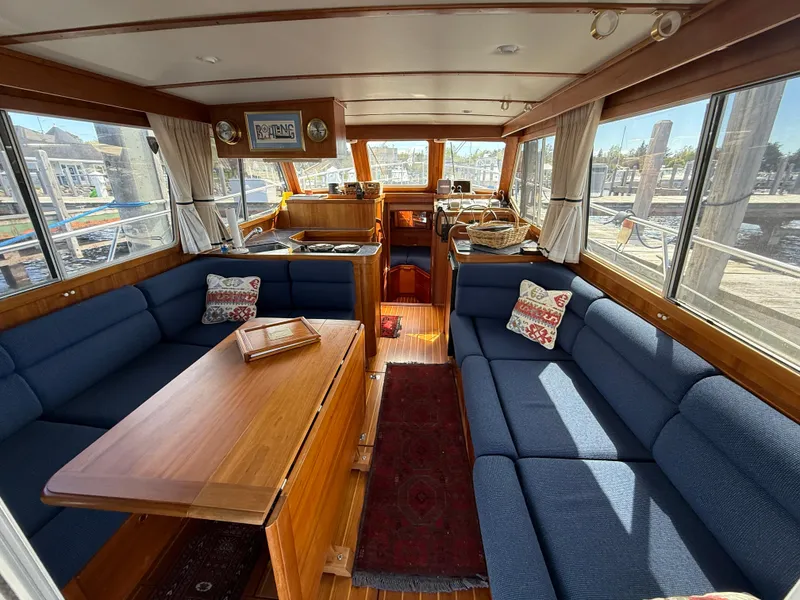 Slide: The Image of Interior of 1999 Sabreline 34 Flybridge yacht with blue seating and wooden accents. - 39