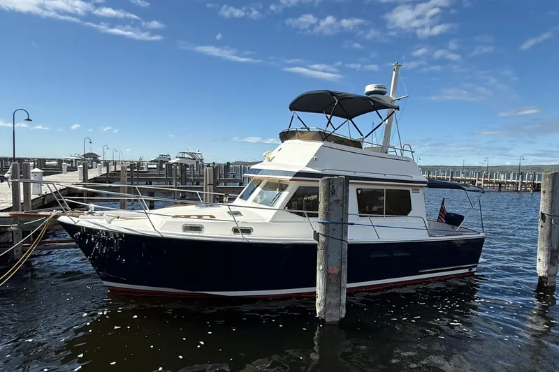 Slide: The Image of 1999 Sabreline 34 Flybridge boat docked at marina under clear blue sky. - 4