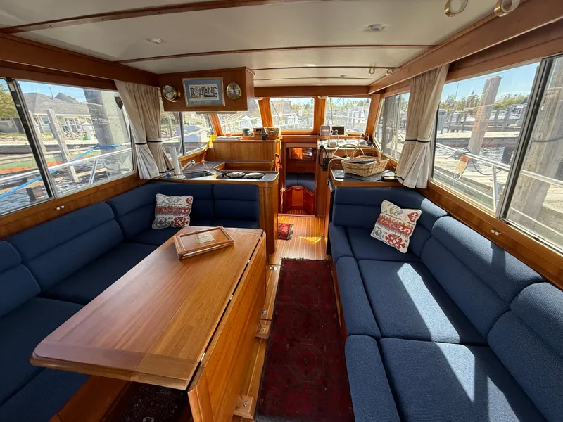 Slide: The Image of Interior of 1999 Sabreline 34 Flybridge yacht with blue seating and wooden table. - 41