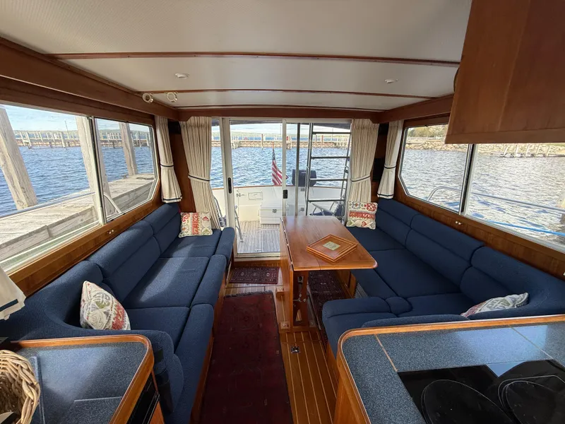 Slide: The Image of Interior of 1999 Sabreline 34 Flybridge with blue seating and wooden table, overlooking water. - 42