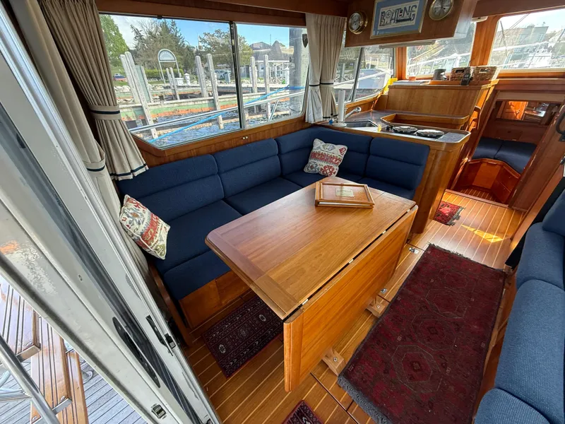 Slide: The Image of Interior of 1999 Sabreline 34 Flybridge yacht with blue seating and wooden table. - 46