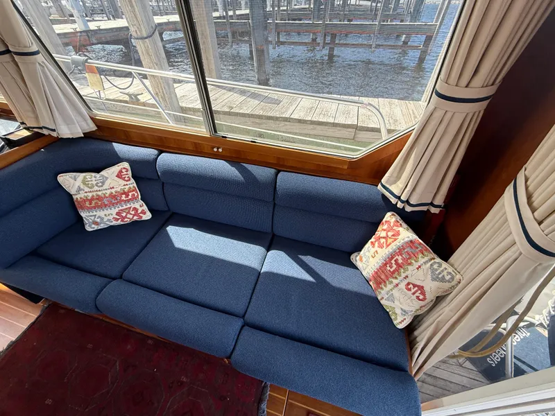 Slide: The Image of Blue sofa with patterned cushions inside a 1999 Sabreline 34 Flybridge boat. - 48