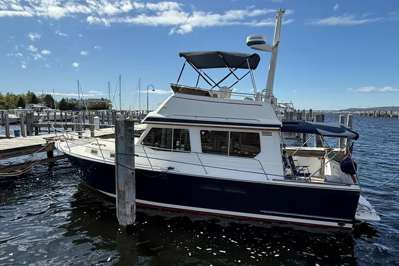 Slide: The Image of 1999 Sabreline 34 Flybridge boat docked at marina under clear blue sky. - 5