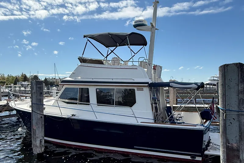 Slide: The Image of 1999 Sabreline 34 Flybridge boat docked at marina under clear blue sky. - 7