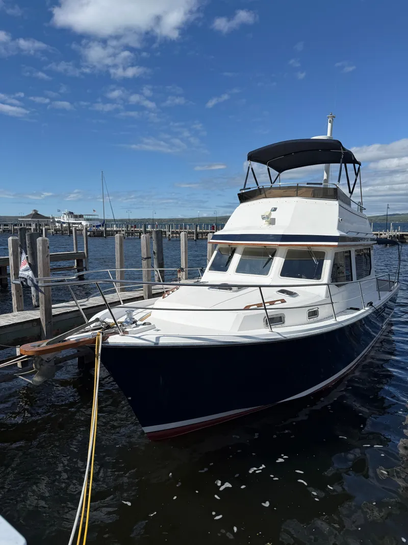Slide: The Image of 1999 Sabreline 34 Flybridge boat docked under a clear blue sky. - 8
