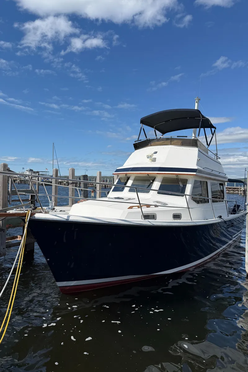Slide: The Image of 1999 Sabreline 34 Flybridge boat docked under a clear blue sky. - 9